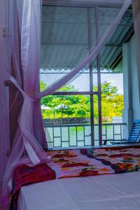 a bed in a room with a window with a view at Hotel Sanasuma in Hambantota