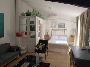 カサール・デ・カセレスにあるCasa Batallaのベッドルーム1室(緑の花瓶が飾られたベッド1台付)