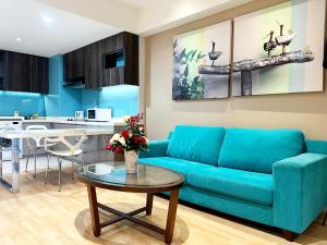 ein Wohnzimmer mit einem blauen Sofa und einem Tisch in der Unterkunft Infini Suites@ D'Majestic Place Kuala Lumpur in Kuala Lumpur