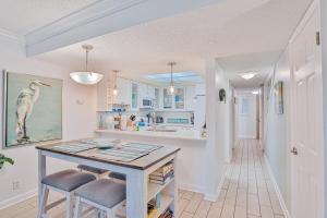 a kitchen with a table and two stools at Modern oceanfront condo with two pools & private washer/dryer in Saint Augustine