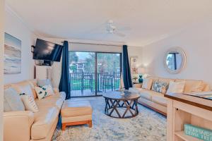 a living room with a couch and a table at Modern oceanfront condo with two pools & private washer/dryer in Saint Augustine
