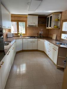 een keuken met witte kasten en een tegelvloer bij Masía con bosque privado in Albinyana
