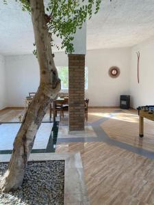 een kamer met een boom en een tafel en een boomstam bij Masía con bosque privado in Albinyana