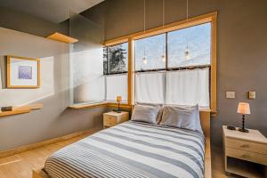 a bedroom with a bed and a window at Madrona Tree Retreat in Coupeville