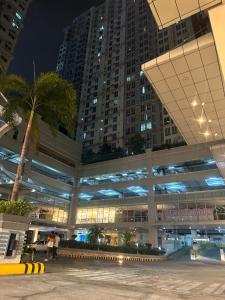 um grande edifício com uma palmeira em frente em The Eden’s Place At San Lorenzo em Manila