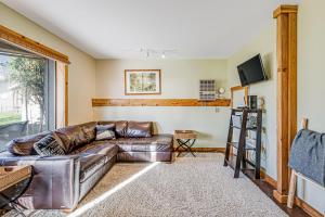 a leather couch in a living room with a window at Madrona Tree Retreat in Coupeville