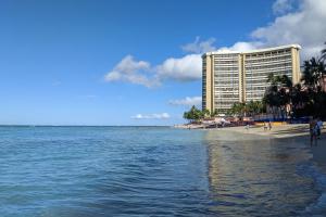 ein großes Hotel am Strand mit einem Gebäude in der Unterkunft Monte Vista 1704 in Honolulu