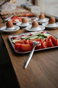 a table with plates of food on a table with eggs at Wake Up Wellness Hostel in Brno