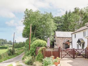 Cottage mit einem Holzzaun und einem Tor in der Unterkunft The Old Barn in Mold