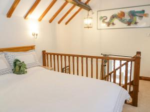 a bedroom with a white bed and a staircase at The Old Barn in Mold