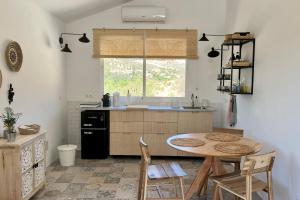 een keuken met een tafel en een wastafel bij Casita Malacitano, Caminito del Rey in Valle de Abdalagís