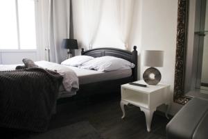 a bedroom with a bed with a mirror and a table at Wake Up Wellness Hostel in Brno