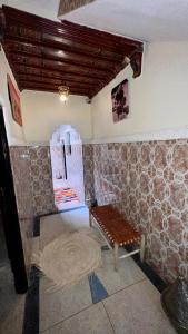 una habitación con una mesa y un banco en una habitación en Riad Hayat, en Marrakech