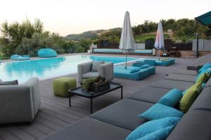 a swimming pool with couches and chairs and a table at Tenuta Pezzapane in Alvignanello