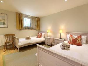 a bedroom with two beds and a chair in it at The Granary in Cheltenham