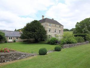 una casa grande con una pared de piedra en un patio en The Granary en Cheltenham