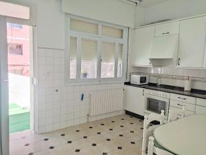 a kitchen with white cabinets and a stove top oven at Celia in Redondela