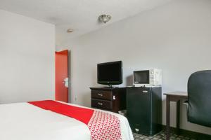 una camera con letto, TV e scrivania di Raceway Inn Darlington By OYO a Darlington