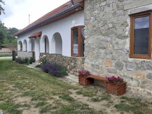 a stone house with a bench in front of it at Menedék - testnek és léleknek 