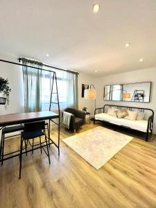 a living room with a bed and a desk at Bright & Spacious 1 bed steps from Hyde Park in London