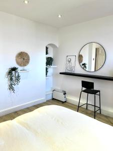 a bedroom with a mirror and a chair at Bright & Spacious 1 bed steps from Hyde Park in London