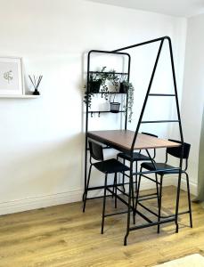 a dining room table with two chairs and a mirror at Bright & Spacious 1 bed steps from Hyde Park in London