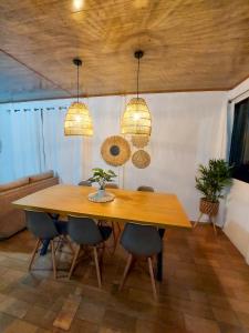 a dining room with a wooden table and chairs at Casa Bambú, con ac y wifi in Puerto Jiménez