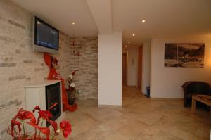 a living room with a fireplace and a tv on a brick wall at Apart Garni Jungmann in Ischgl