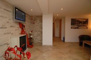 a living room with a fireplace and a tv on a brick wall at Jungmann Apartments in Ischgl