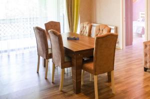 uma mesa de jantar com cadeiras e uma mesa de madeira em Family Inn em Ismailli