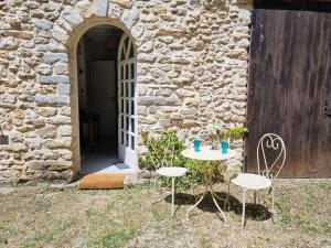 a table and two chairs in front of a building at La Parenthèse Campagnarde in Richarville