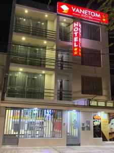 a building with a neon sign in front of it at Hotel Vanetom in Chiclayo