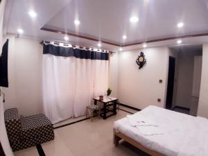 a bedroom with a bed and a table and a window at Dunleigh Apartments in Murree