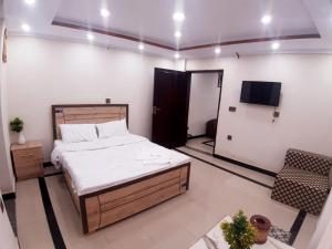 a bedroom with a bed and a tv in it at Dunleigh Apartments in Murree