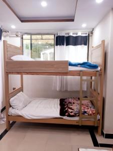 two bunk beds in a room with a window at Dunleigh Apartments in Murree