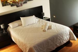 un letto con lenzuola bianche e 2 cuscini sopra di Hotel Vanetom a Chiclayo