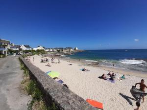 a group of people on a beach near the ocean at Escale à Lomener in Ploemeur