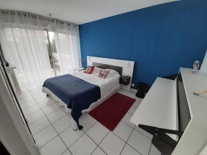 a bedroom with a bed and a blue wall at Escale à Lomener in Ploemeur
