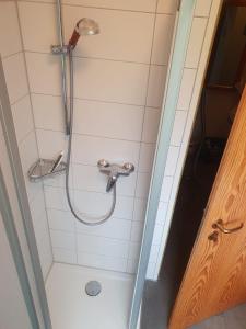 a shower with a shower head in a bathroom at Mövenschiss in Wremen
