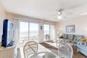 a living room with a couch and a tv at Island Sands 306 in Fort Walton Beach