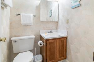 a bathroom with a white toilet and a sink at Island Sands 306 in Fort Walton Beach +10 photos