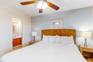 Island Sands 306 في شاطئ فورت والتون: غرفة نوم بسرير ومروحة سقف