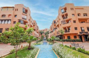 馬拉喀什的住宿－Appartement Premium Village, 5 piscines，城市中一条有建筑物和河流的街道