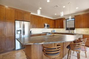 a kitchen with wooden cabinets and a kitchen island with bar chairs at Red Rock Wonder in St. George