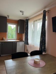 Zimmer mit einem Tisch und einer Küche mit einem Fenster in der Unterkunft Brīvdienu namiņš in Ludza