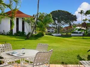 a patio with a table and chairs in a yard at Kiahuna Plantation Kauai by OUTRIGGER - Select Your Unit in Koloa