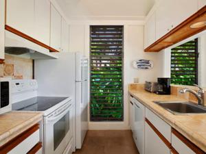 a kitchen with white appliances and a sink at Kiahuna Plantation Kauai by OUTRIGGER - Select Your Unit in Koloa