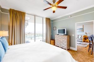 a bedroom with a bed with a ceiling fan and a television at Destin West Resort - Gulfside PH03 in Fort Walton Beach