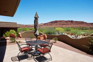 a table and chairs with an umbrella on a patio at Red Rock Wonder in St. George