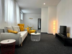 a living room with a couch and a tv at BREZA HOUSE apartments in Zlín